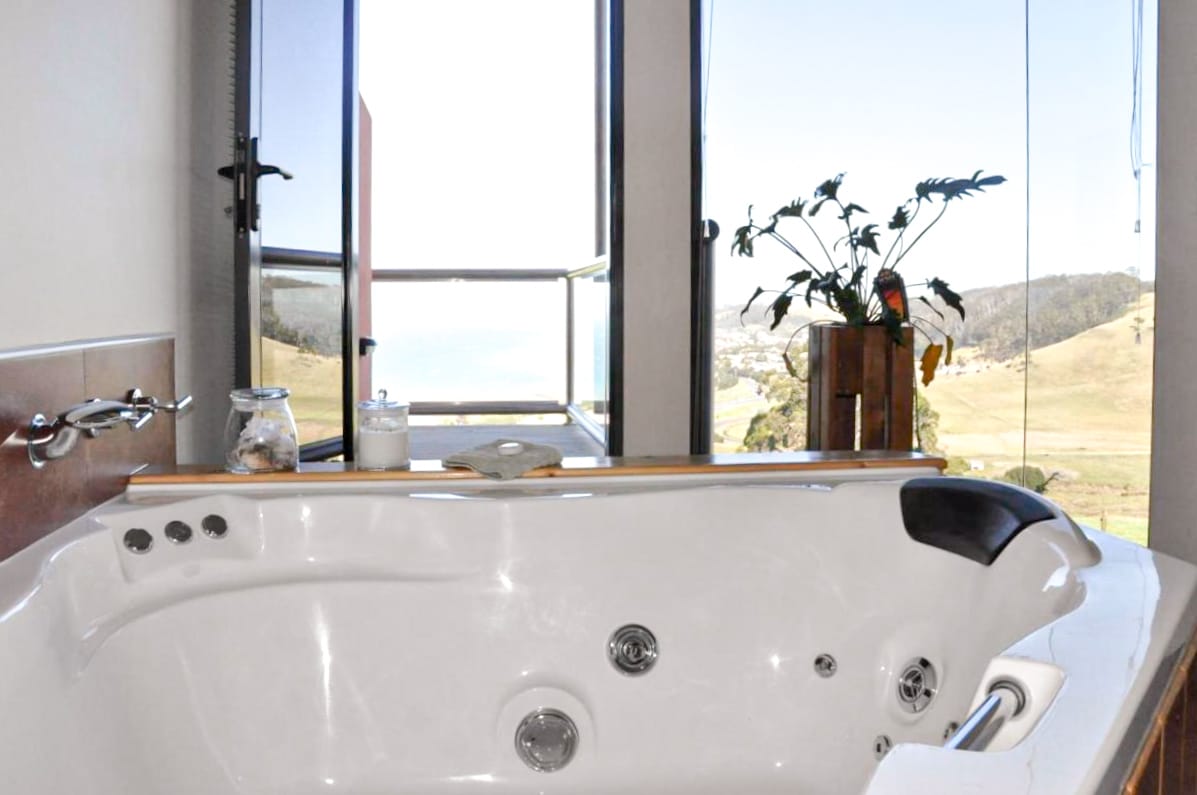 Luxurious bathtubs at Black Rock Retreat with an outlook over rolling hills and the ocean.