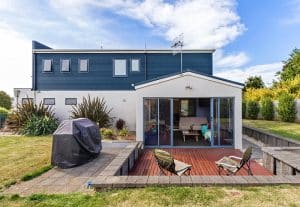 A painted blue and white colourbond pet friendly beach house in North West Tasmania. The back deck is sunken below lawn level and there's a bbq for entertaining.