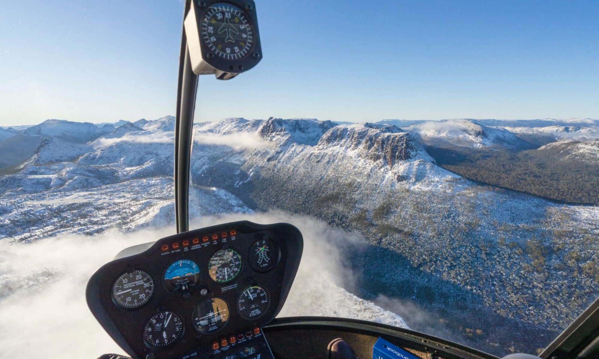 View from a helicopter flying over snow-covered mountains in North West Tasmania near Cradle Mountain