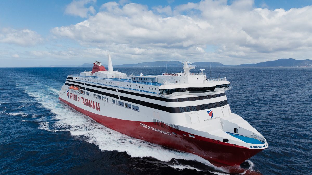 Aerial view of the red and white Spirit of Tasmania IV ferry at sea, with hills on the horizon