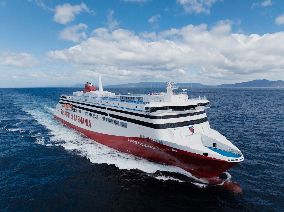 Aerial view of the red and white Spirit of Tasmania IV ferry at sea, with hills on the horizon